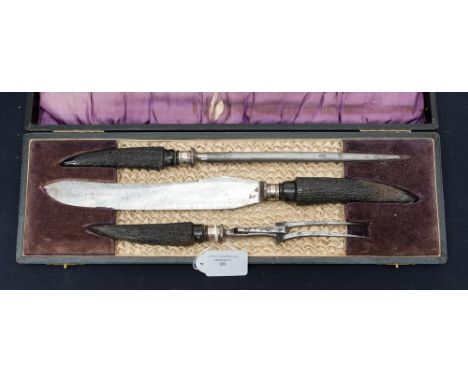 An Edwardian cased three piece antler handle carving set, silver ferrules hallmark Sheffield 1913