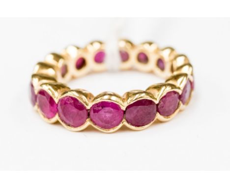A ruby full eternity style yellow gold ring with collet rubover settings. Size O1/2 with a total gross weight approx 7.8gms