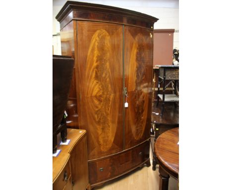 An Edwardian mahogany bow fronted wardrobe, in the Sheraton manner