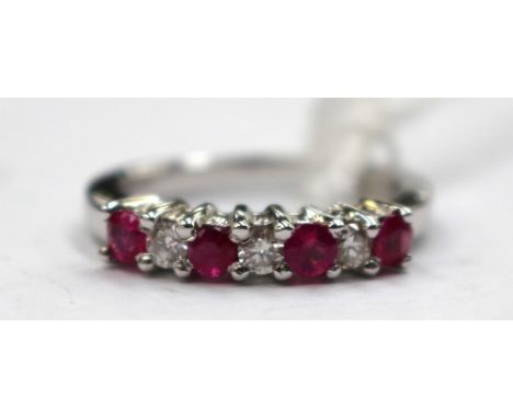 An 18ct white gold diamond and ruby half eternity ring. The ring comprises of four rubies and three diamonds, finger size M1/