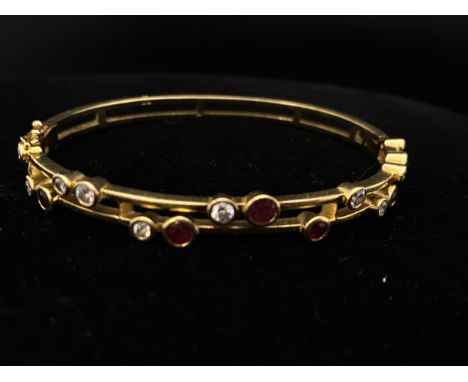 A heavy tests for 18ct gold bangle set with diamonds &amp; rubies. 24.89 grams. 