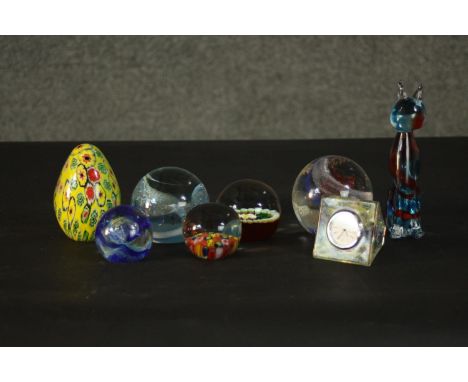 A collection of art glass paperweights, including a yellow Millefiori egg paperweight, a floral design lamp work paperweight 