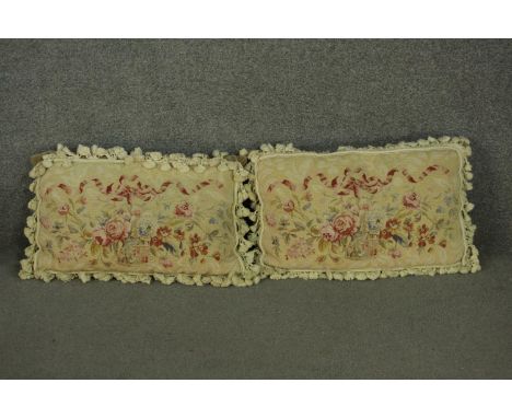 A pair of Aubusson type rectangular cushions, depicting a ribbon tie over a basket of flowers, with tassels around the edge. 