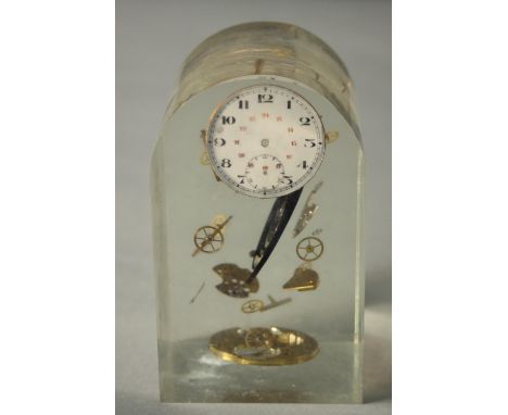 A deconstructed clock parts clear acrylic paperweight. H.13 W.8 D.8cm. 