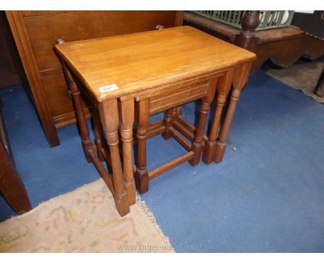 A light Oak nest of three occasional Table standing on turned legs, the largest 20'' x 13 3/8'' x 18 3/4'' high