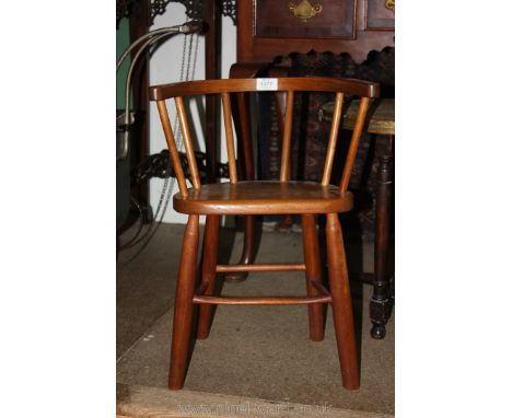 A solid wood seated child's Bow back Armchair having turned legs, stick stretchers and back supports and in the style of a ca