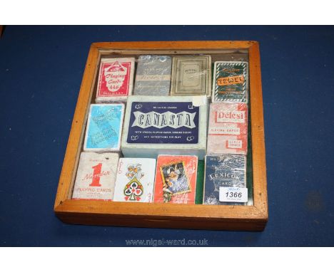 A small display Cabinet with sets of playing cards.