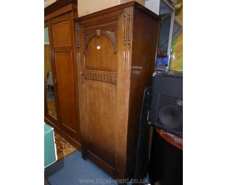 An Oak single Wardrobe, the door having arch and fluted detail, the interior with hanging space and a hat shelf, 31 1/8'' wid