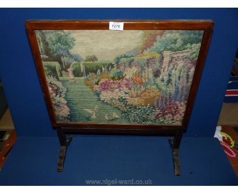 A small wooden Firescreen having tapestry of birds in a garden.