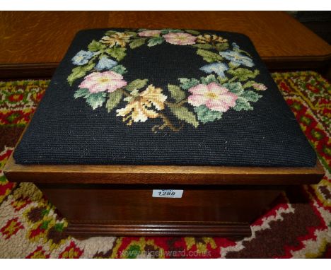 A tapestry lidded square shaped Footstool standing on bun feet.