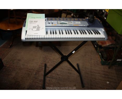 A Casio LK110 Keyboard with stand and song book