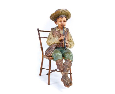 An Austrian Painted Terracotta Figure of Rustic Musician, late 19th/early 20th century, formed as a seated boy playing a flut
