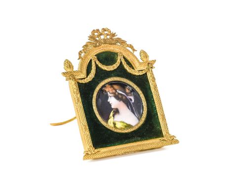 A Limoges Enamel Plaque, late 19th/early 20th century, painted with a bust portrait of a maiden with ribbon-tied hair, in a g