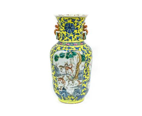 A Chinese Porcelain Vase, 19th century, with loop handles, painted in underglaze blue with lotus scrolls on a yellow ground a