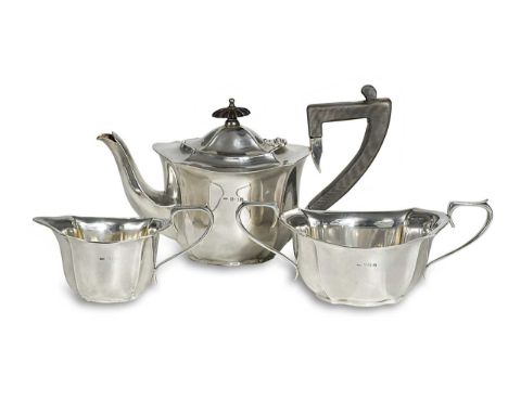 A George V silver three-piece tea set, mark of William Hair Haseler Ltd., Birmingham 1913, the teapot of oval fluted form wit