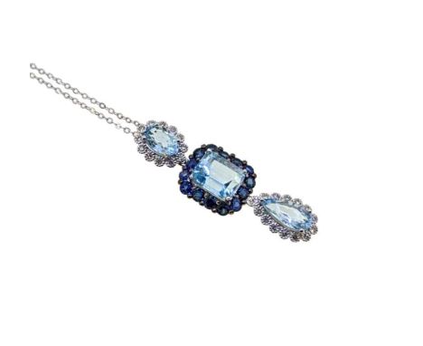 A modern aquamarine and sapphire pendant and chain, triple drop pendant, with an oval faceted aquamarine surrounded by diamon