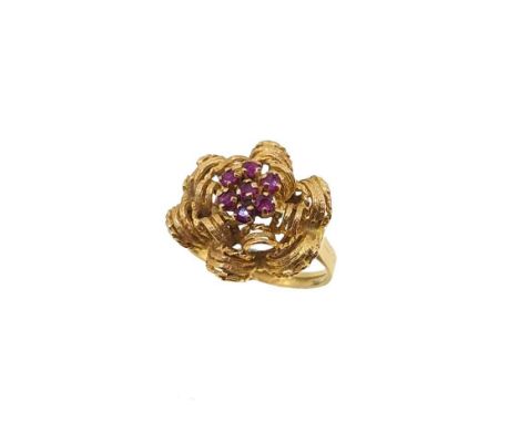 A ruby cluster ring, openwork flower with a central cluster of seven claw set round faceted rubies, head diameter 18.3mm, sli