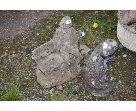 A concrete figure of a man sat on a garden bench, plus an otter.