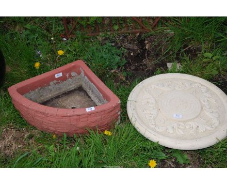 A corner concrete planter and a sundial top.