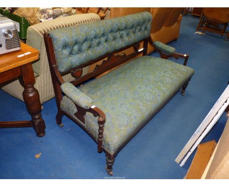 A modern framed Sofa upholstered in blue/green fabric.