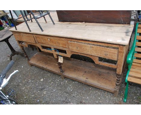 An Oak pot board Dresser base having three drawers and pot shelf, 73" long x 16" deep x 34" high.