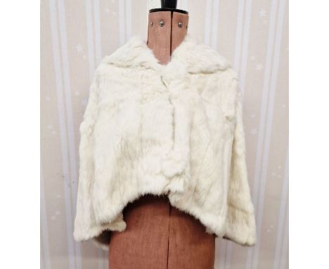 A vintage ermine cape, hooded, the back slightly longer than the front, with circular fur button fastenings, the lining embro