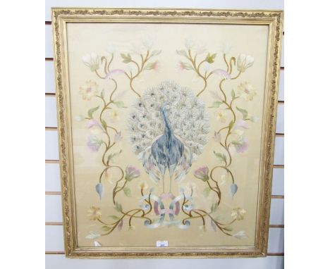 Early 20th century silk needlework picture of a peacock, standing between flowering branches, on an ivory silk ground, within