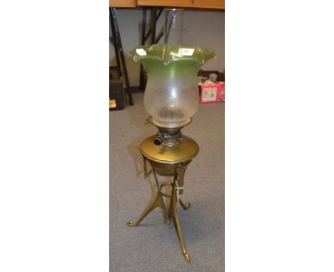 An Arts and Crafts brass table oil lamp, with frosted, clear and green glass shade, and clear glass chimney, 66 cm high