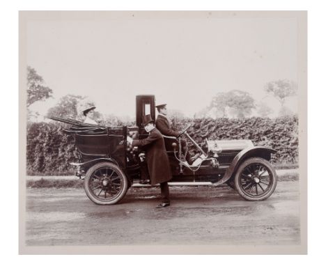 An early 20th century black and white photograph, of a gentleman wearing a top hat and tails entering a Rolls-Royce Silver Gh