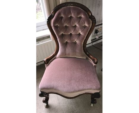 A 19thC spoonbacked walnut nursing chair on cabriole legs and ceramic castors. 