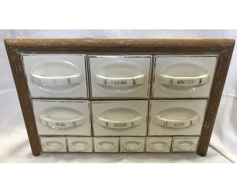 A French kitchen spice and food cupboard, the labelled ceramic drawers fitted in a wooden frame. 35 h x 54 w x 15cms d.