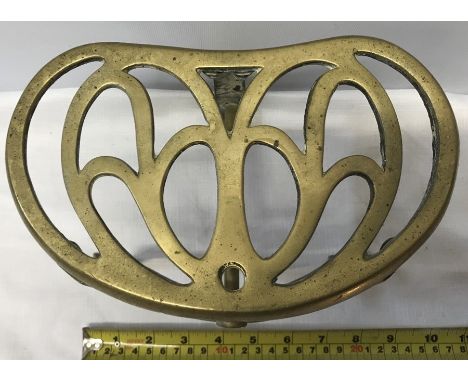 An Art Nouveau brass trivet. 16 h x 23cms w. 