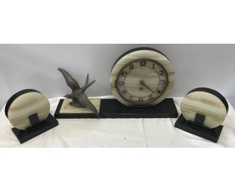 A French Art Deco two colour marble and onyx clock garniture with circular dial mounted to one side with bird in flight with 