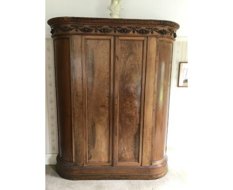 A continental fruitwood double wardrobe with 2 doors and curved sides, single shelf and a hanging rail. Fruit and swags carve