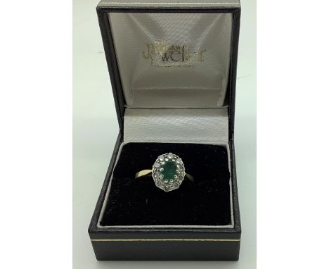 A diamond and emerald cluster ring set in 9 carat gold, centre emerald surrounded with diamonds. 2.8gms. Size Q. 