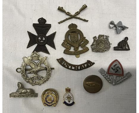 Collection of military cap badges and other pin badges, WW I tank pin badge, WW II German badge, other badges including Royal