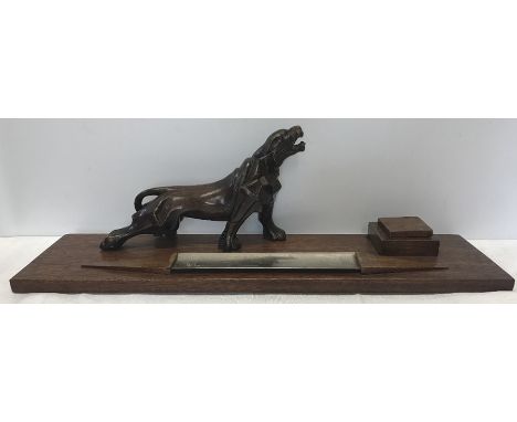 A reconstituted desktop pen and inkstand surmounted by a carved big cat of Semi-Abstract Cubist form with metal pen rest and 