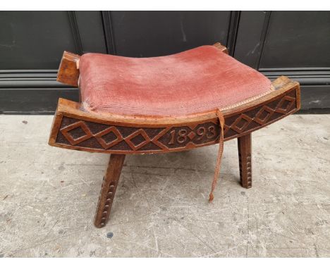 An unusual Victorian carved walnut saddle stool, initialled&nbsp;'W R' and dated 1893, 55.5cm wide.&nbsp;&nbsp; 
