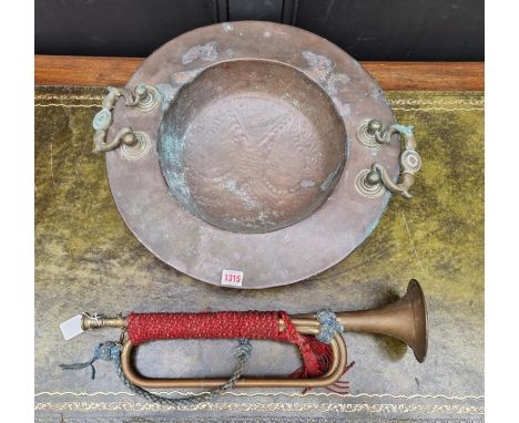 A large Eastern copper and brass twin handled basin, 48cm diameter; together with a brass trumpet. (2) 