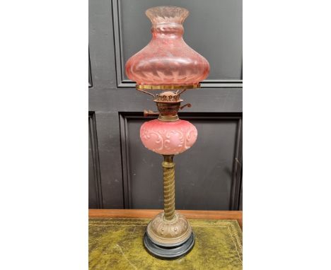 A Victorian brass and opaque glass oil lamp,&nbsp;with cranberry shade, 72.5cm high, (lacking chimney). 