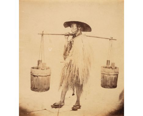 * Japan. A Japanese water carrier in a straw raincoat and hat by Felice Beato (1830-1906) Japan, c. 1865, albumen print, smal