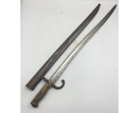 A 19th century French M1866 Chassepot bayonet, complete with scabbard. Of usual form, featuring a ribbed brass grip, with pus