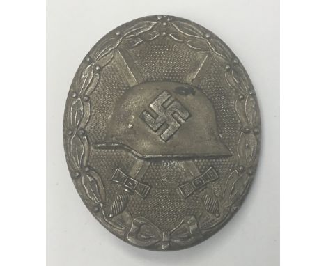 A WW2 era German silver grade wound badge. A die cast example made in silvered zinc, with solid back, a round hinge, and C cl