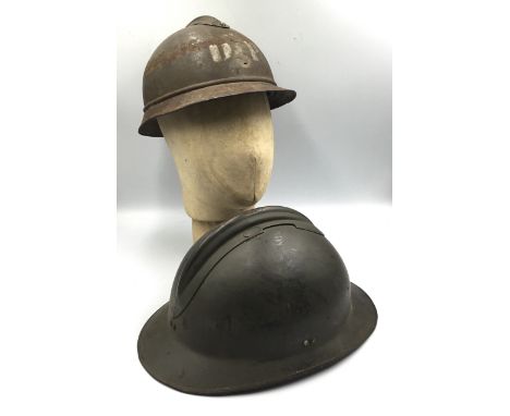 A pair French Adrian helmets, including WW1 and WW2 examples. The WW1 M15 example is complete with its top comb, and the usua
