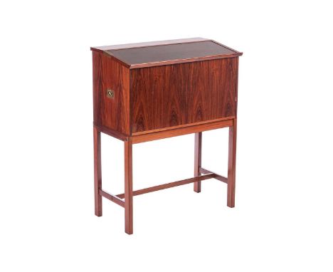 A 1970s Dyrlund rosewood reading desk/bar, the black vinyl inset slope with inset brass mounts hinged to form a larger flat s