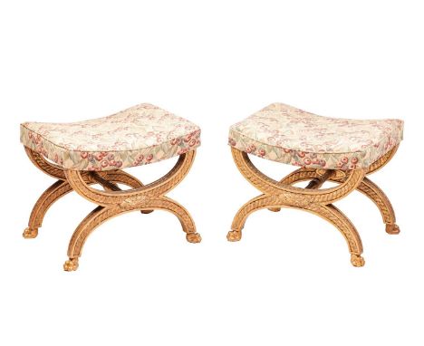 A pair of Regency carved wood and gilt gesso curule form stools with saddled seat, the "x" frame with recessed panels of guil