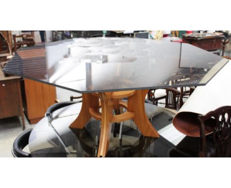 A contemporary octagonal glass-topped dining table raised on light oak support, diameter 161cm.