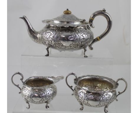 A Victorian hallmarked silver three-piece tea service, each of squat circular form with repoussé floral decoration surroundin