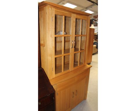 A modern light oak dining room suite comprising display cabinet, dining table, six dining chairs with arched back supports an