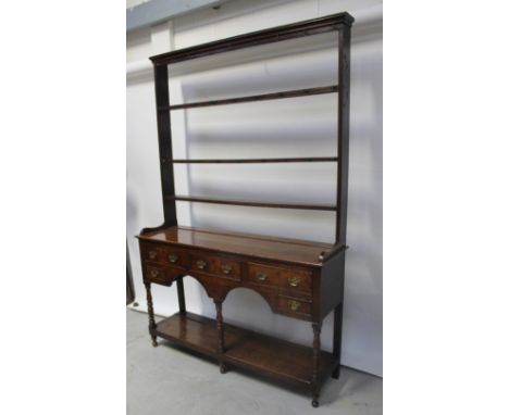 An 18th century oak dresser with plate rack back and three large drawers above two smaller drawers and undertier shelf, raise